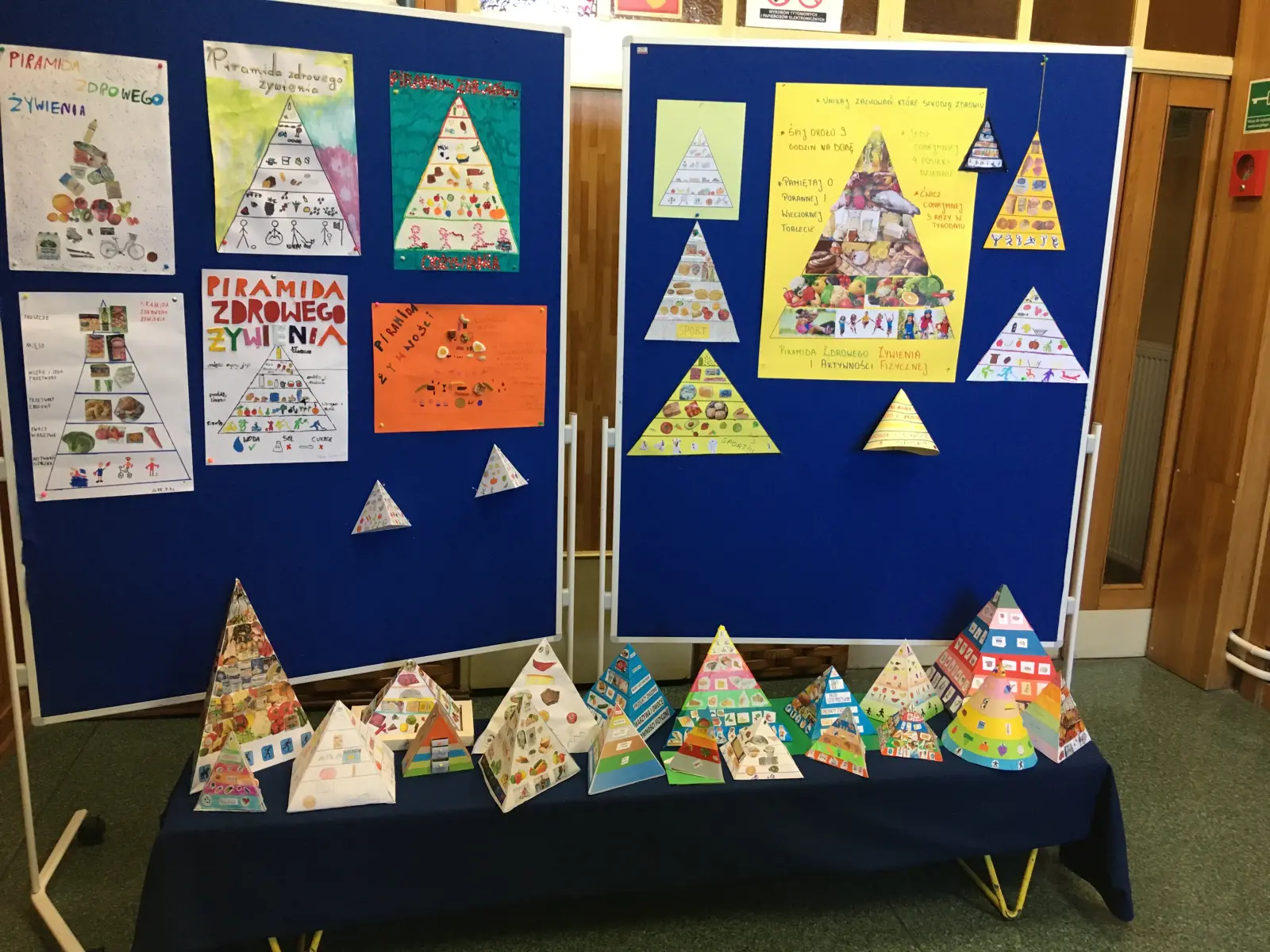 Kolorowe piramidy zdrowego odżywiania wykonane przez uczniów klas czwartych