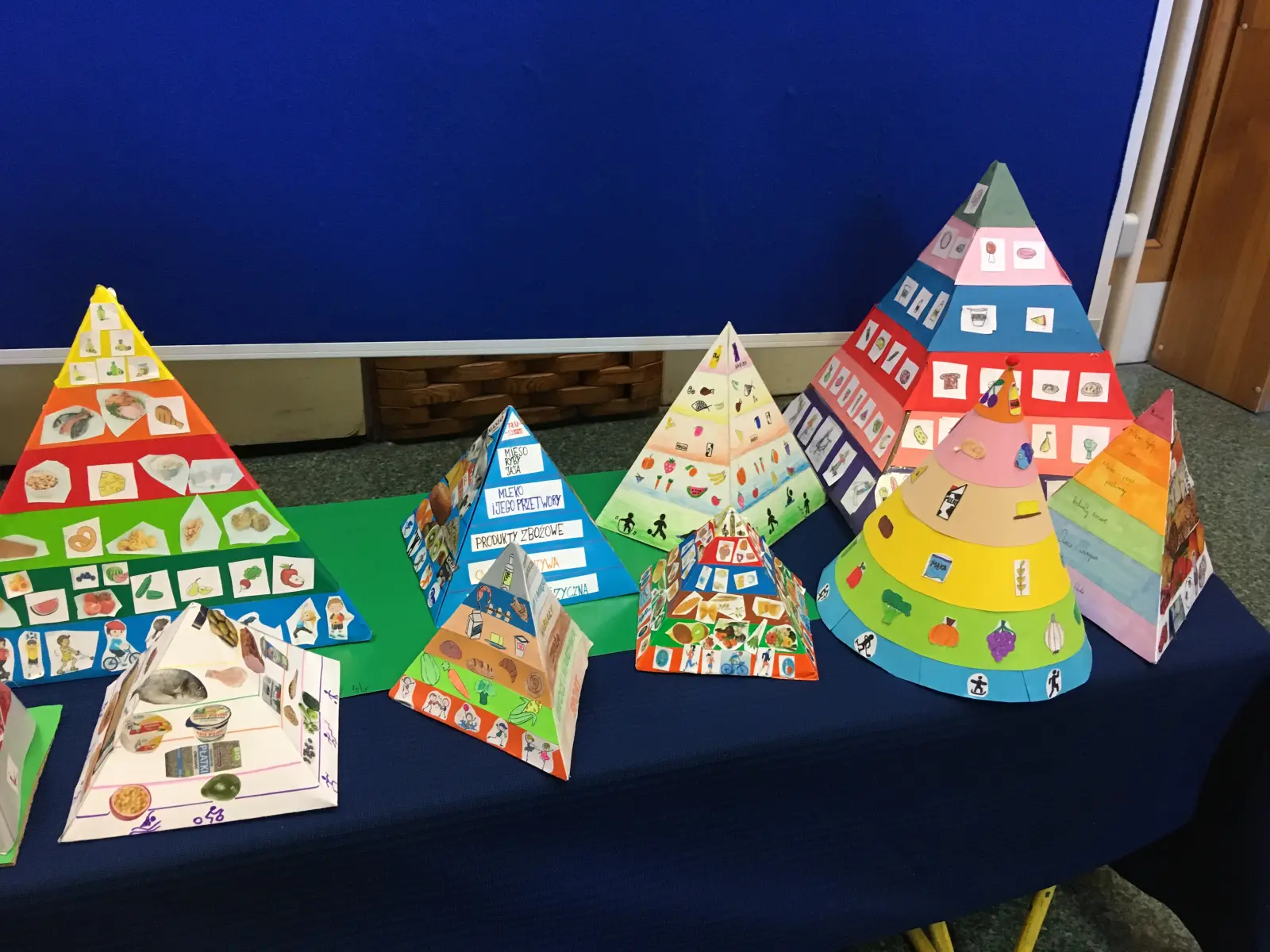 Kolorowe piramidy zdrowego odżywiania wykonane przez uczniów klas czwartych