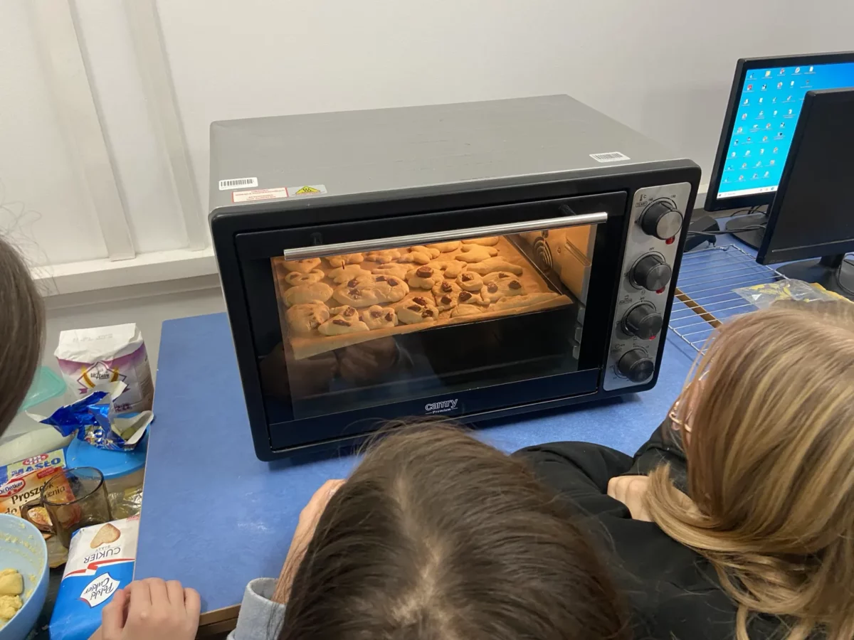 Ciasta pieką się w piekarniku. Uczniowie z niecierpliwością czekają na efekty swojej pracy.